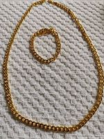 Necklace and bracelet laid flat on textured cloth
