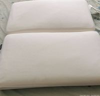 Two clean white king size memory foam pillows placed side by side, showing smooth surface.