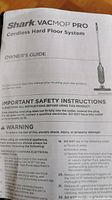 Close-up image of Shark Vacmop Pro owner's guide showing safety instructions and product identification.