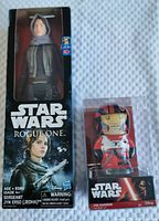 Frontal shot showing Sergeant Jyn Erso figurine and Poe Dameron wind-up toy in original boxes.