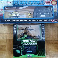 Photo of the two helicopters in original boxes showing the Phantom yellow helicopter and the Hornet black and green helicopter.