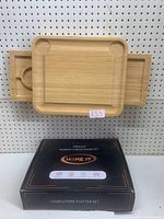 Main bamboo charcuterie board with smaller tray sliding out from beneath and packaging box in background