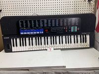 Full front view of Casio Tone Bank CT-670 keyboard showing 61 keys, key numbers and control panel labels, placed on white surface