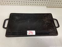 Top view of the cast iron BBQ skillet flat side showing two handles and rectangular shape.