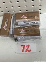 Three Coors Light gold power banks in original packaging with charging cables visible.