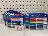 Two packs of EXPO fine tip dry erase markers (8 markers each) and two packs of EXPO chisel tip dry erase markers (4 markers each) displayed hanging on pegboard.