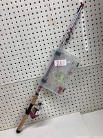 Full fishing rod mounted with attached tackle box and reel, showing length and handle in cork.