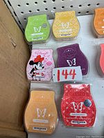 Six Scentsy scent bars in various colors and theme including Minnie Mouse pink themed bar arranged on a surface.