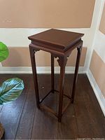Full view of the Henredon solid wood plant or decor stand showing the tall slender legs and square top.