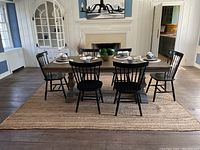 Dining room view showing rectangular braided jute area rug under dining table and chairs on hardwood floor