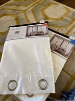 Curtain panels still in original Middleton Home packaging showing white textured fabric and metal hanging grommets.