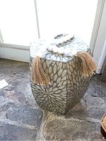 Side table hexagonal shape showing floral shell inlay pattern on top and sides with decorative wooden beads and tassels.