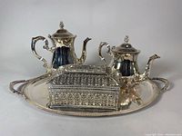 Photo showing full set with ornate hinged box on large serving tray along with two silver plated pots