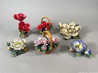 Full view of all six floral porcelain figurines in various colors and basket arrangements