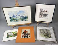 Overview of all five pieces laid out showing three framed and two unframed artworks, including the June Gerum signed watercolour and variety of floral and landscape subjects.