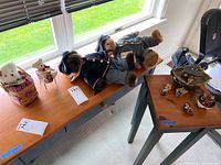 Wide shot of the full collection of Boyd's Bears including Civil War dressed bears lying on table, bear on basket, and other small bear figurines on a chair and in thematic displays.
