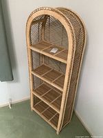 Full view of the wicker shelf, showing its four shelves and curved top design.