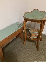 Wooden bench, wall table and lidded box arranged together, showing painted floral designs and overall set style.