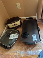 Three electric cooking appliances: West Bend cooker with floral design, Rival electric skillet with glass lid, and large Presto electric skillet with temperature control knob on top.