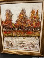 Full view of the large vintage framed oil painting showing colorful autumn trees with reflection in water.