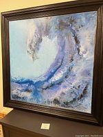 Full view of large square framed painting with abstract wave design in blue and purple hues.