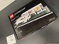 Front of boxed LEGO Architecture Farnsworth House 21009 on black surface with lot number card