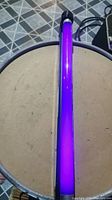 Top-down view of the black light fluorescent tube emitting purple light.