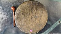 Top view of wooden gong with mallet next to it on metal surface