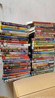 Two stacks of DVDs showing colorful spines with various kids movie titles.