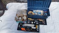 Wide shot of the Mastercraft blue toolbox filled with piano strings and repair supplies, and two black plastic trays filled with various tools and small parts.