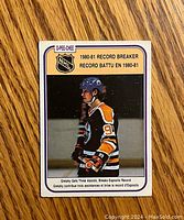 Front side of 1980-81 O-Pee-Chee Wayne Gretzky hockey card showing Gretzky in Edmonton Oilers uniform number 99 with text highlighting record breaking assists.