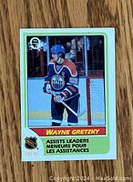 Front of the card showing Wayne Gretzky in Edmonton Oilers uniform with player name and assists leaders text