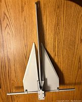 Full view of the Fortress FX-7 anchor showing its aluminum flukes and shank, laid flat on a wooden surface.