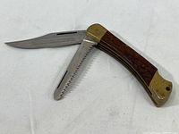 Open view of Puma Game Warden pocket knife showing wooden handle with brass bolsters and both blades extended (cutting blade and saw blade).