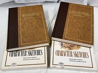 Pair of two large hardcover books with marbled brown covers and dark brown spines titled 'Character Sketches' with their matching dust jackets beneath them, showing front covers with text and colored nature illustration.