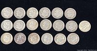 Top view showing rows of 19 Roosevelt dimes on black background arranged in three rows with dates visible