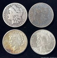 Four silver dollars: top row two Morgan (1881, 1898), bottom row two Peace (1922)