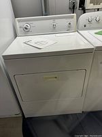 Front view of the white Kenmore electric dryer with top control panel and closed front door.