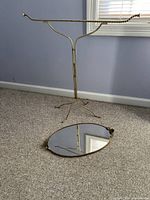 View of both items together, quilt stand standing upright with tray placed on floor in front