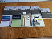 Photo showing five Kaplan LSAT prep books, one Princeton Review LSAT book, an Official LSAT Handbook, a Law School Essays guide, and a 2013 LSAT practice test book.