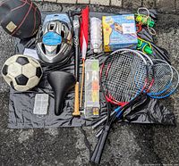 Overview of sports and outdoor equipment included in the lot, showing balls, helmet, rackets, bat, fishing kits, and other accessories.