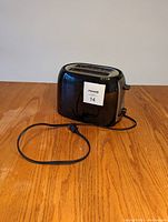 Side view of Black & Decker toaster showing black plastic body, power cord and front lever with control buttons.