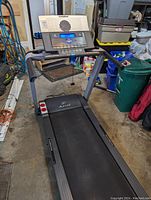 Front angle view of NordicTrack A2155 treadmill, showing digital console with blue screen and running belt in garage environment.