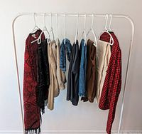 Full view of 10 women's clothing items on rack, showing variety including jackets, cardigans, pants, skirts, and shorts.