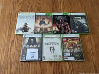 Front shot of all the 8 Xbox 360 game cases showing cover art for each game including Fable II, Fable III, Fallout New Vegas, Fallout 3, FEAR 2, Oblivion, LEGO Indiana Jones, and Kung Fu Panda.