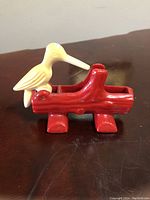 Front angle photo showing red log shaped toothpick holder with white bird perched, used condition.