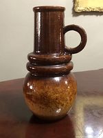 Full view of Scheurich Keramik West German pottery vase with handle, showing fat lava brown glaze and circular handle