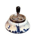 Front angle view of the vintage signed Delft porcelain push ashtray showing the hand-painted windmill and floral designs with metal push top and black knob.