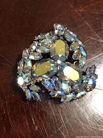 Front view of vintage signed Sherman brooch showcasing clear and aurora borealis rhinestones in a floral wreath design.