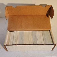 Open cardboard box showing a large number of baseball cards organized upright in rows.